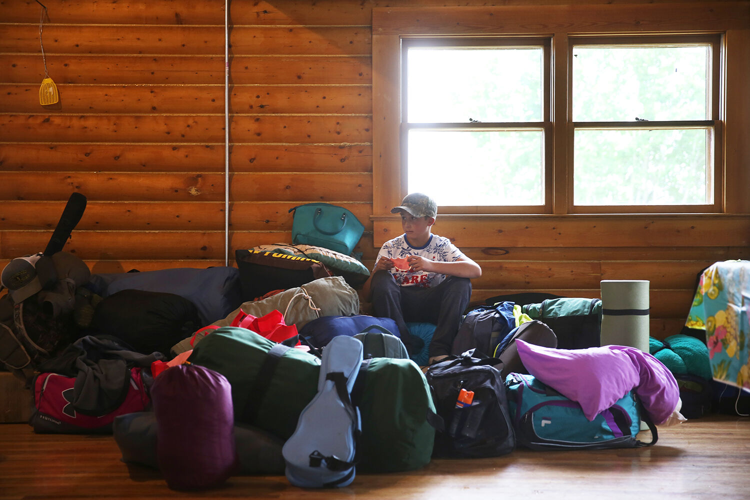 Henry Shoup snacks on a piece of ham amongst the growing pile of sleeping bags
